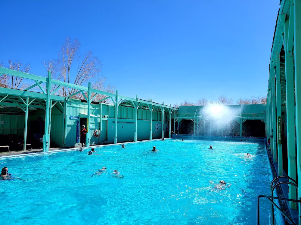 people soaking at developed outdoor hot spring pools with turquoise water at keoughs hot springs in california