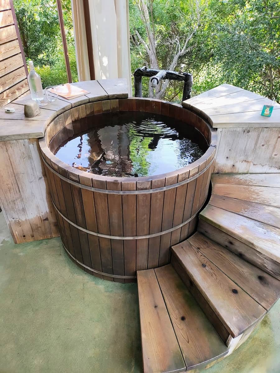 Outdoor wooden spring tub in a resort setting at camp hot wells in texas