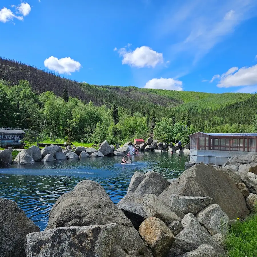 Outdoor hot spring pool with forest backdrop at chena hot springs resort in alaska