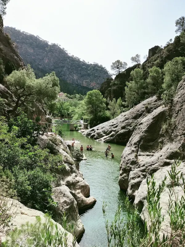 People soaking in a hot spring river in a gorge at la fontcalda in spain