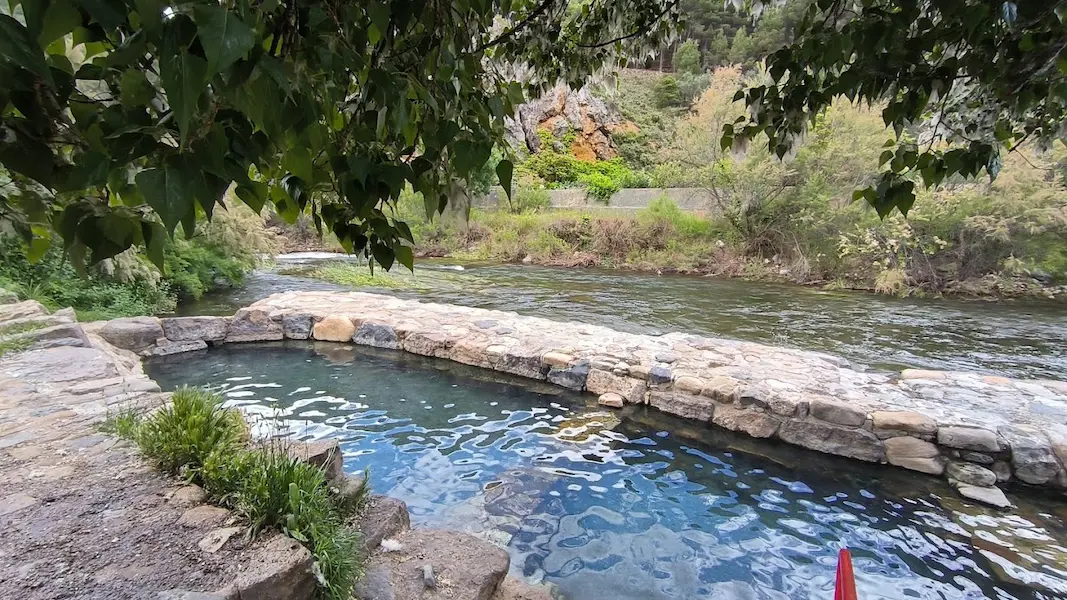 Outdoor concrete hot spring pools next to a river at pozas de arnedillo in spain