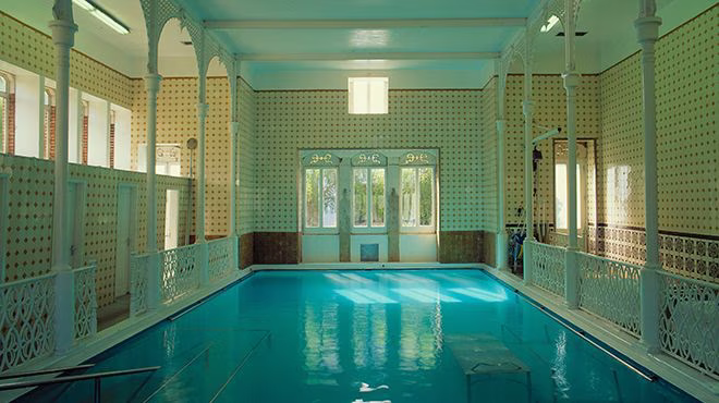 Indoor hot spring pool with natural lighting at termas de caldelas in portugal