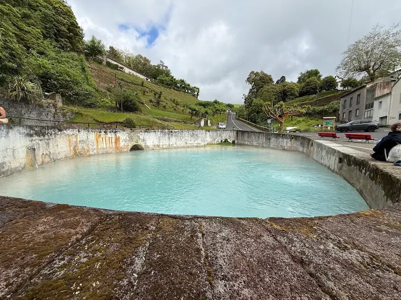 Outdoor turquoise thermal pools surrounded by lush hills at caldeiras da ribeira grande in portugal