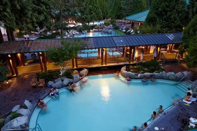 people soaking in Japanese inspired hot spring pools in a resort setting at harrison hot springs resort in canada