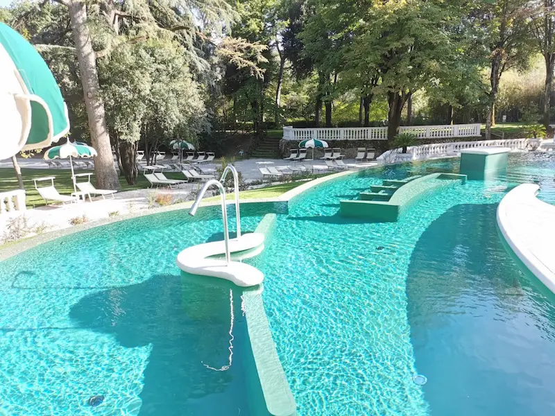 Outdoor developed thermal pools with turquoise water and surrounded by trees at terme di castrocaro in italy