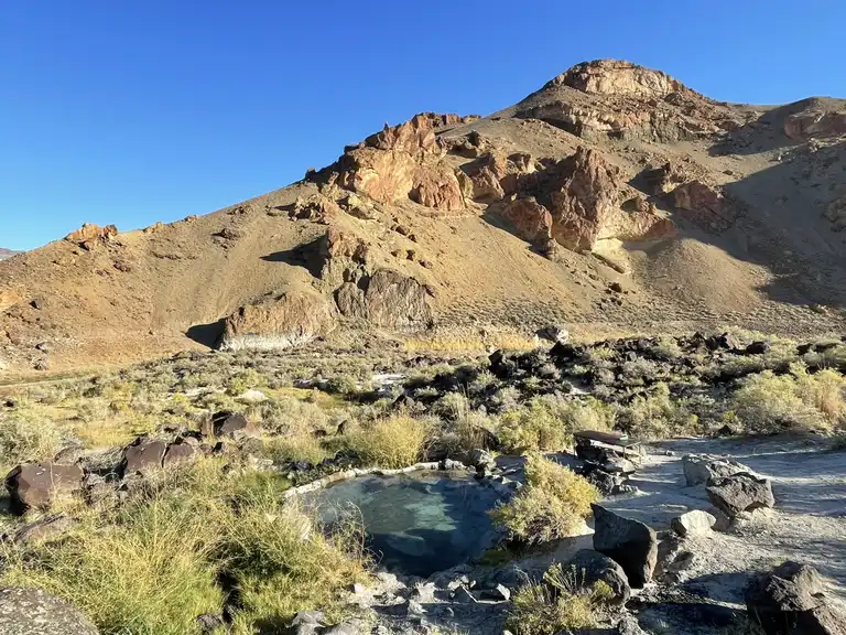 Outdoor rock lined hot spring pool in a desert setting at echo rock hot springs in oregon