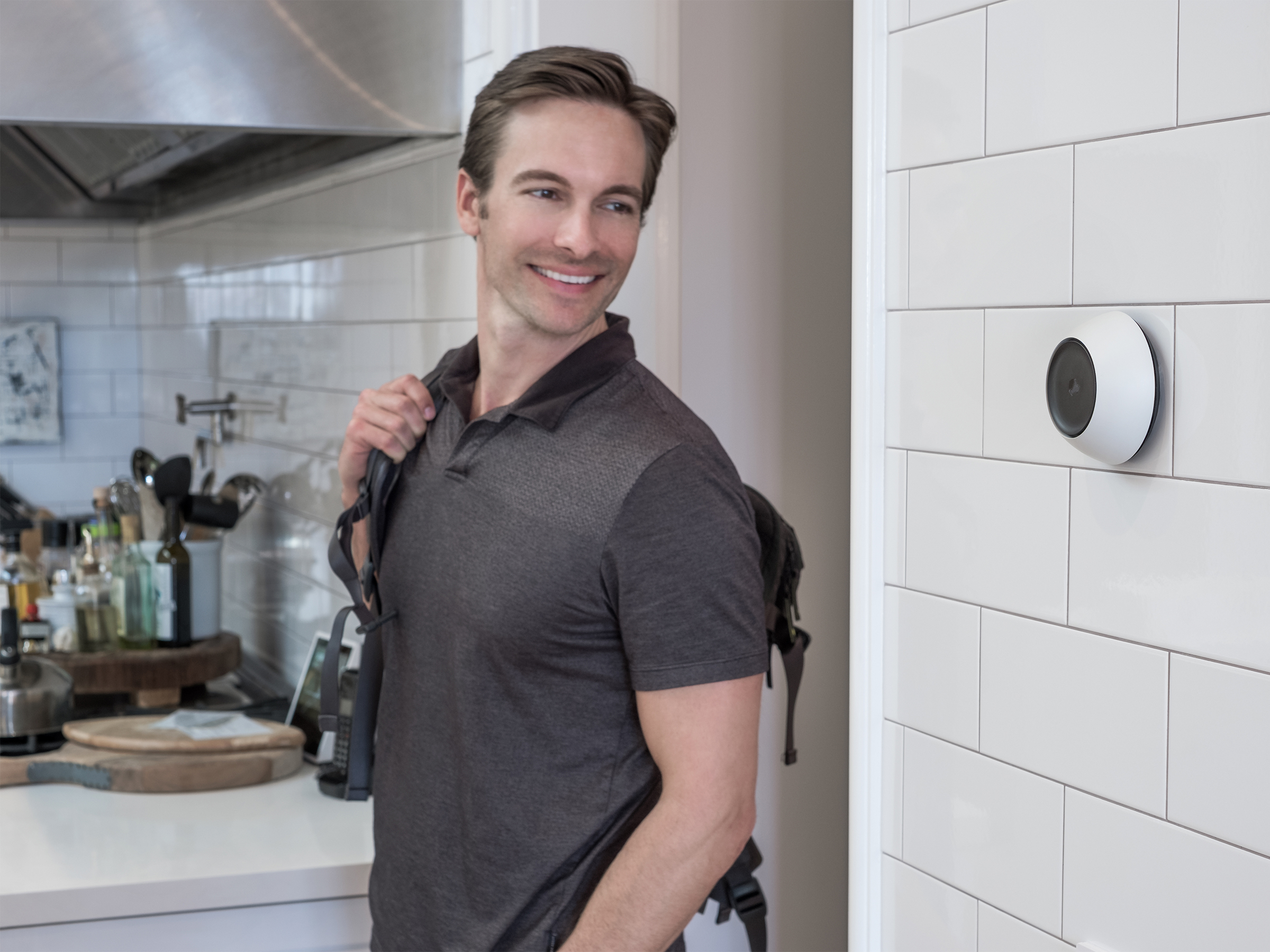 Man leaving a kitchen past a wall-mounted Josh Micro
