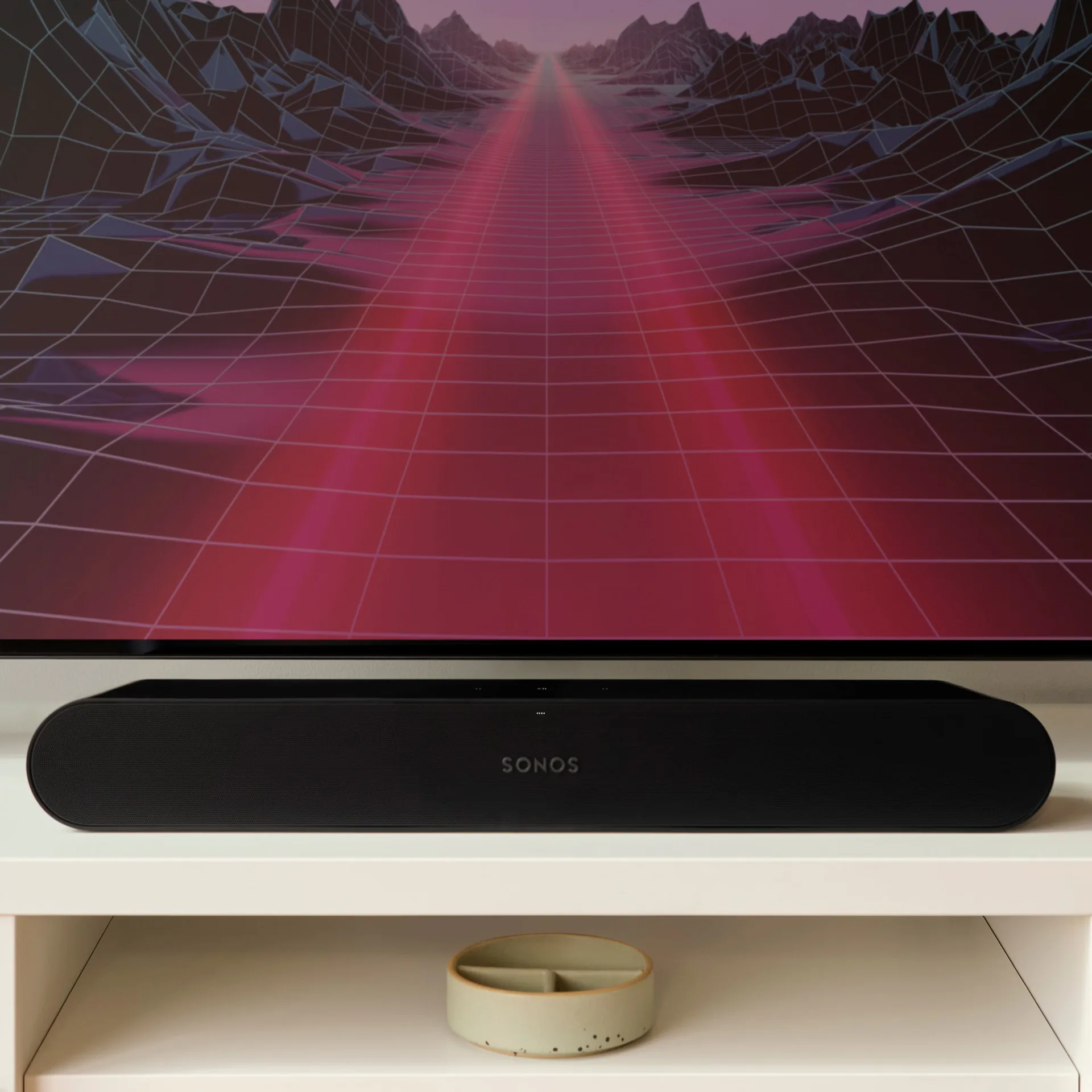 Sonos soundbar below a television showing a neon synthwave landscape