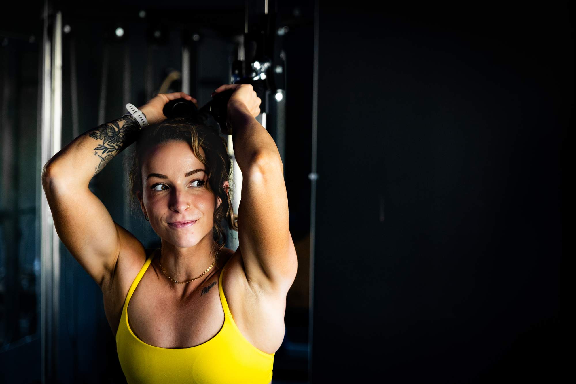 woman does tricep extensions in the gym