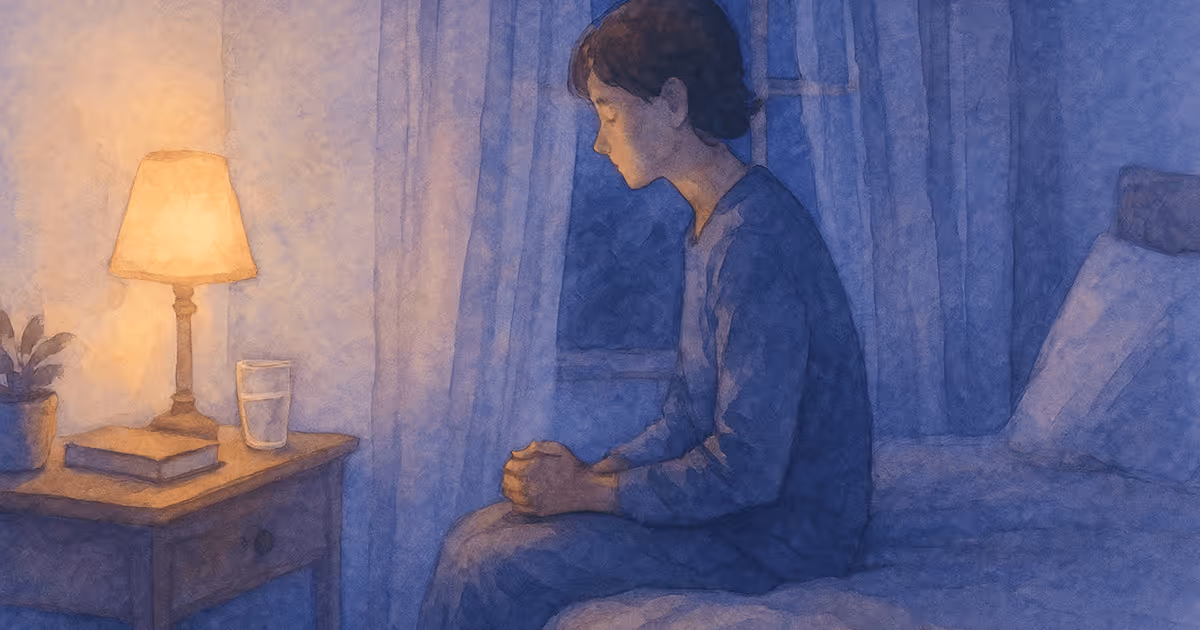 A watercolor illustration of a person sitting on a bed at night with hands clasped, facing a softly lit bedside table with a lamp, book, and glass of water.