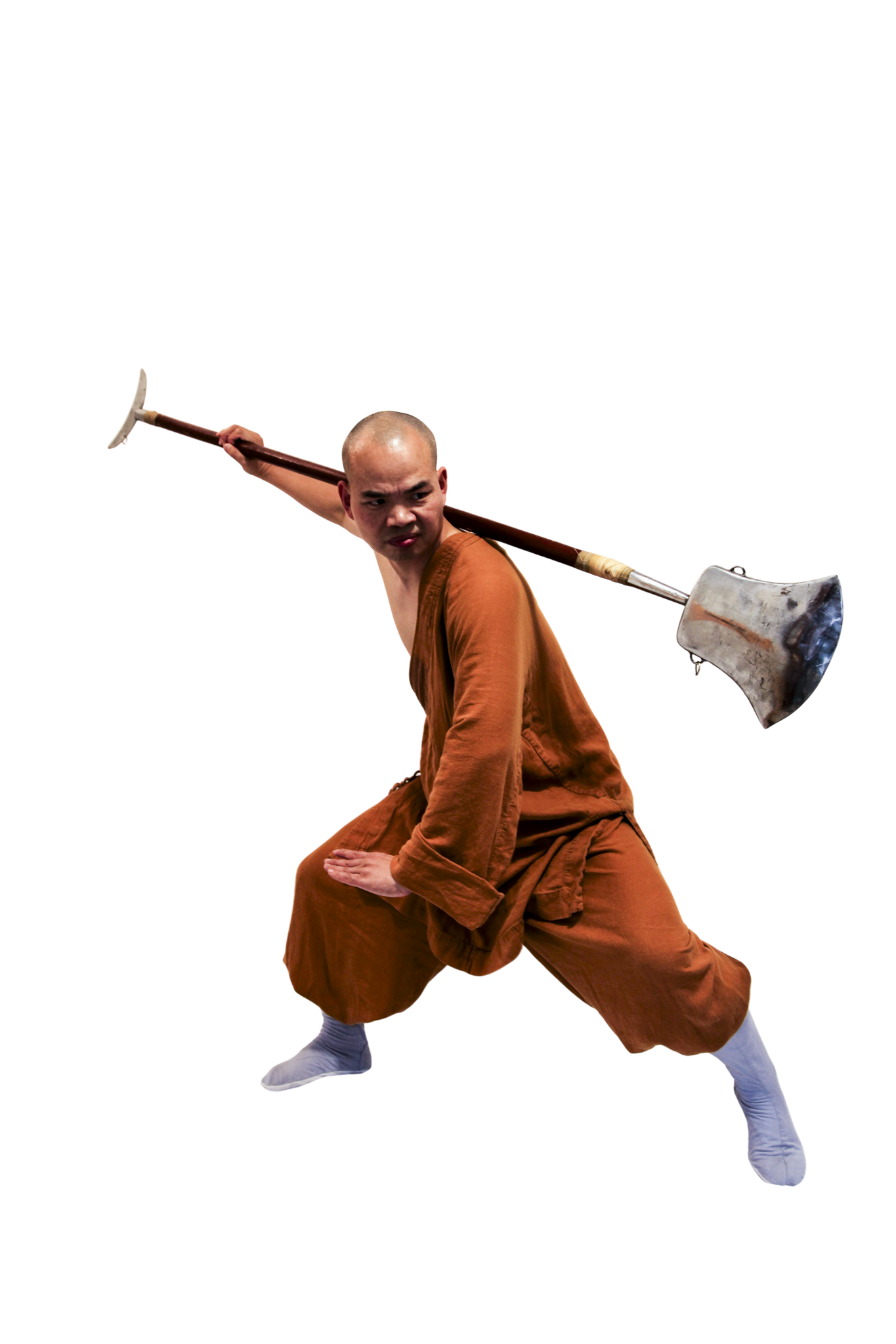 Martial artist in orange robe in a low defensive stance holding a large pole weapon over his shoulder.