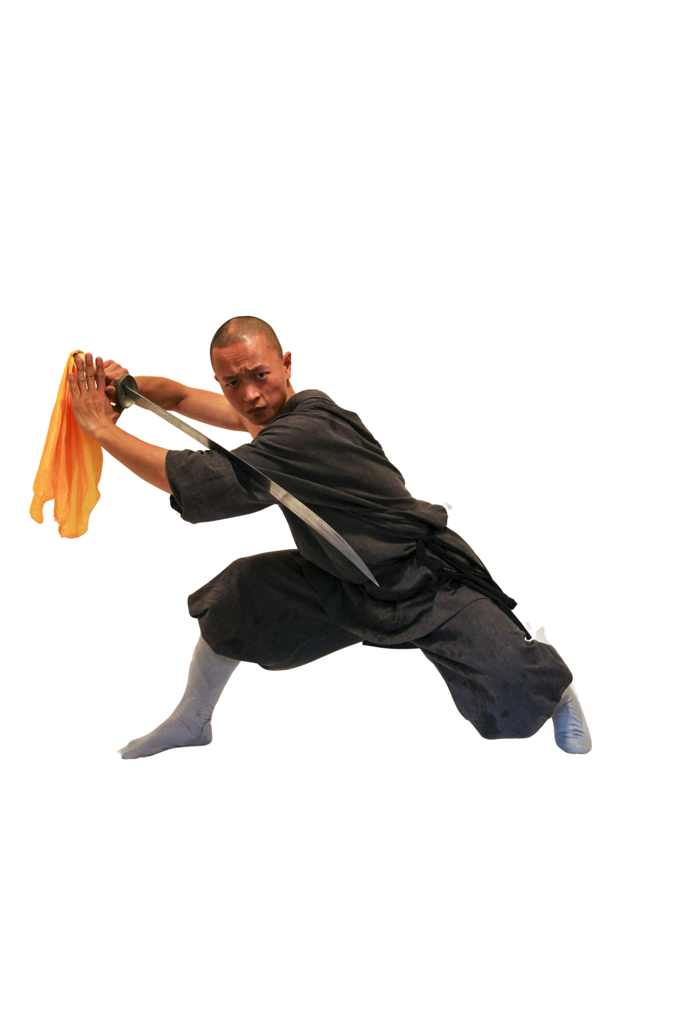 Martial artist in mid-air jump holding a sword with a yellow cloth, dressed in gray traditional attire.