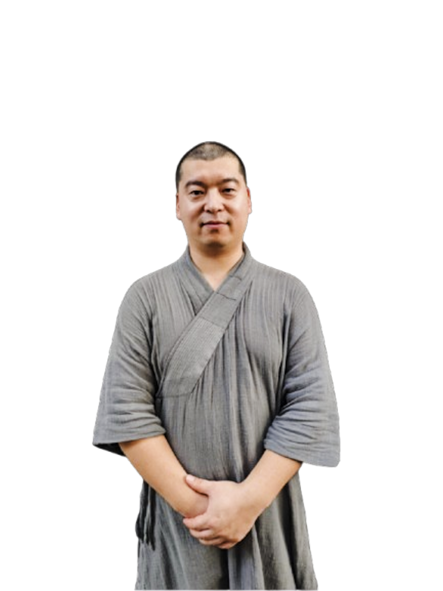 Man wearing a gray traditional robe with folded hands, looking at the camera with a neutral expression.