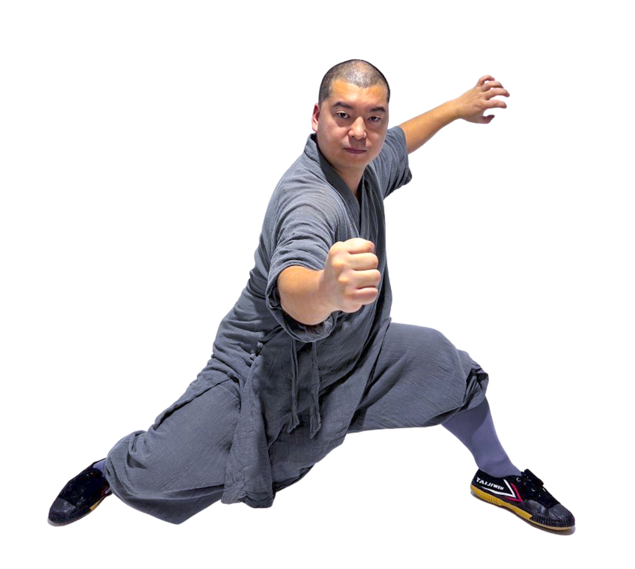Martial artist in gray traditional outfit performing a high jump punch with focused expression.