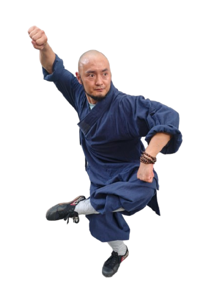 Man in traditional martial arts uniform performing a high kick with clenched fists.