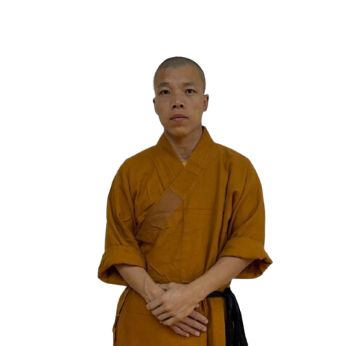 Young man wearing a traditional orange martial arts robe standing with hands clasped.