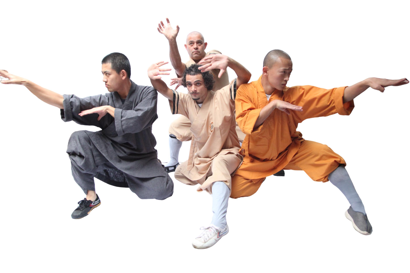 Four martial artists in traditional robes performing dynamic kung fu stances against a white background.