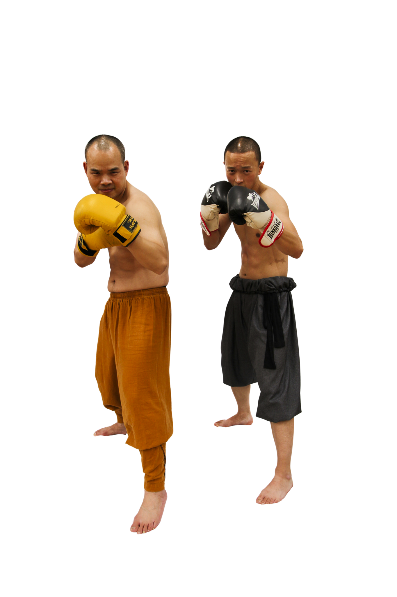 Two shirtless male martial artists in fighting stances wearing boxing gloves and loose pants, one with yellow gloves and brown pants, the other with black gloves and gray pants.martial art london Shaolin Xiu