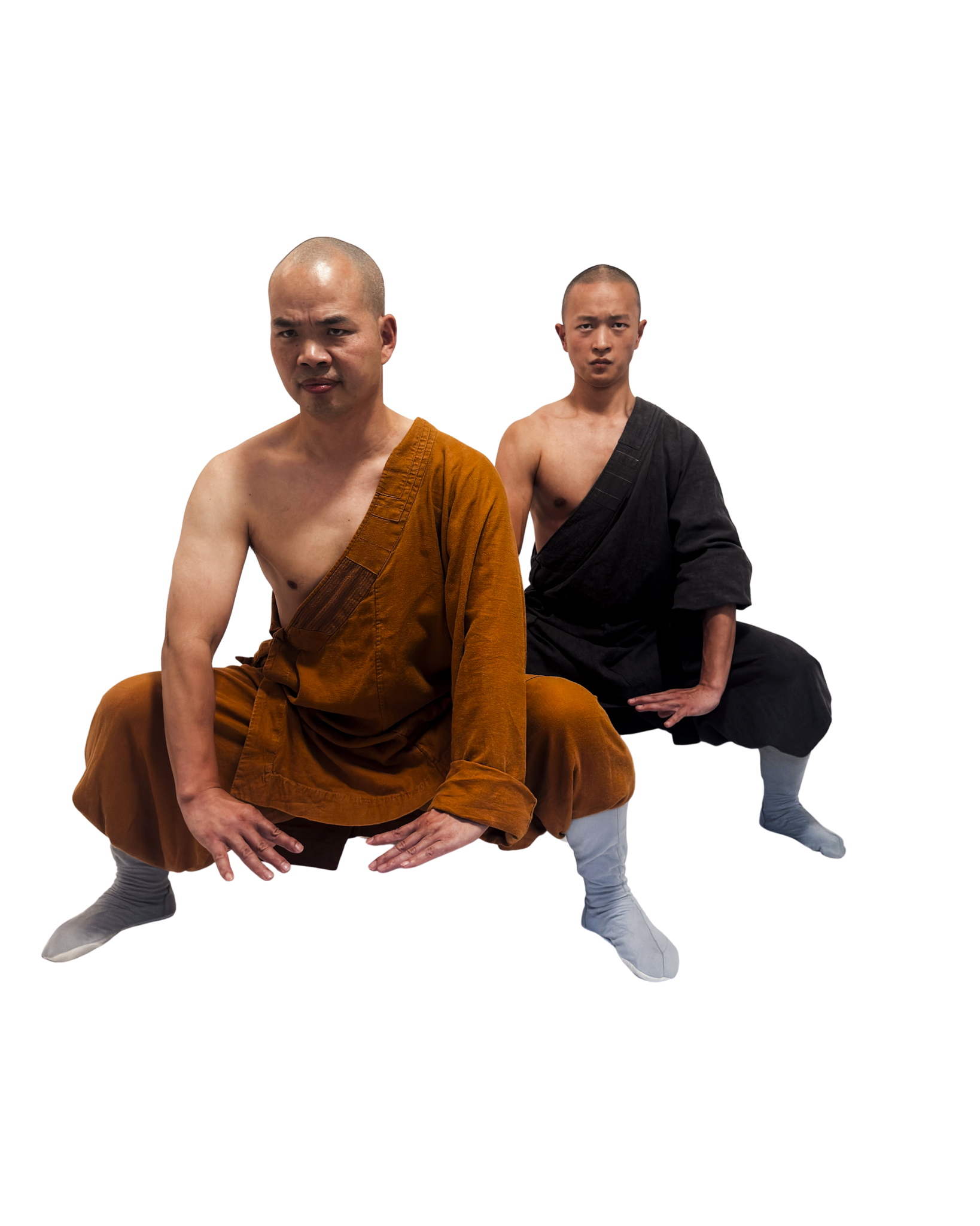 Two martial artists in monk-style clothing performing low stances, one in brown and one in black robes with gray footwear.martial art london Shaolin Xiu