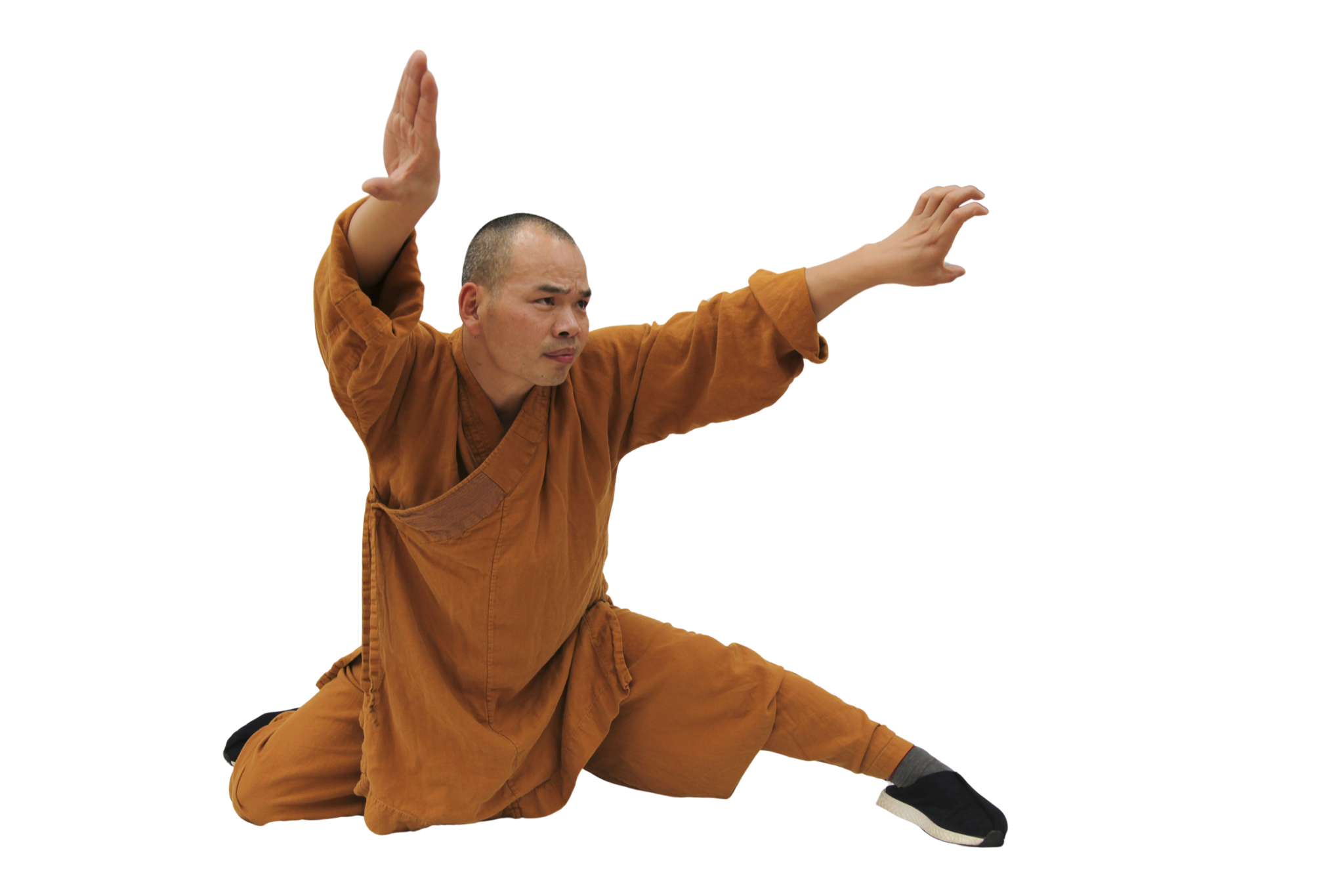 Martial artist in brown traditional uniform performing a low balanced kung fu pose with one leg extended and arms positioned for defense. martial art london Shaolin Xiu