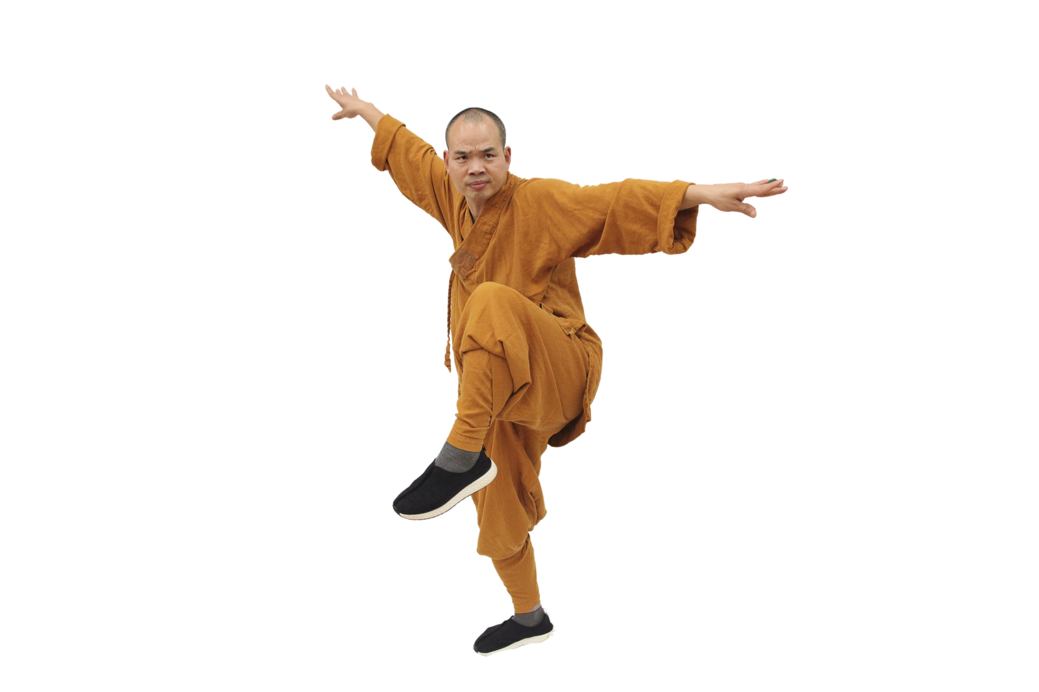 Man in orange traditional martial arts clothing performing a balanced kung fu pose on one leg with arms extended.martial art london Shaolin Xiu