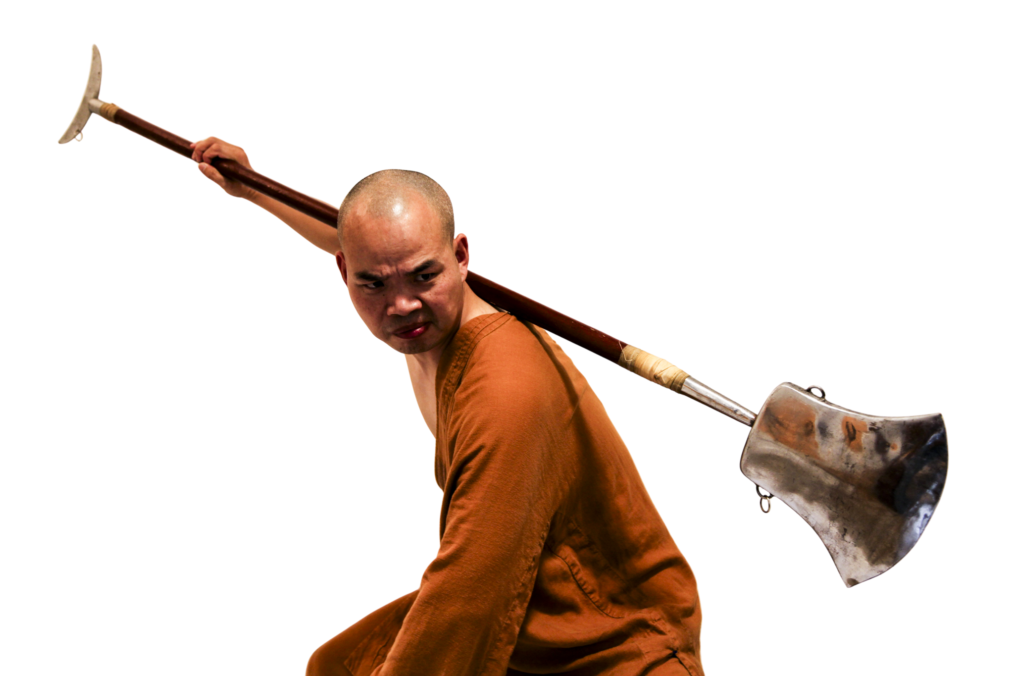 Man in an orange robe holding a large farming hoe over his shoulder.martial art london Shaolin Xiu