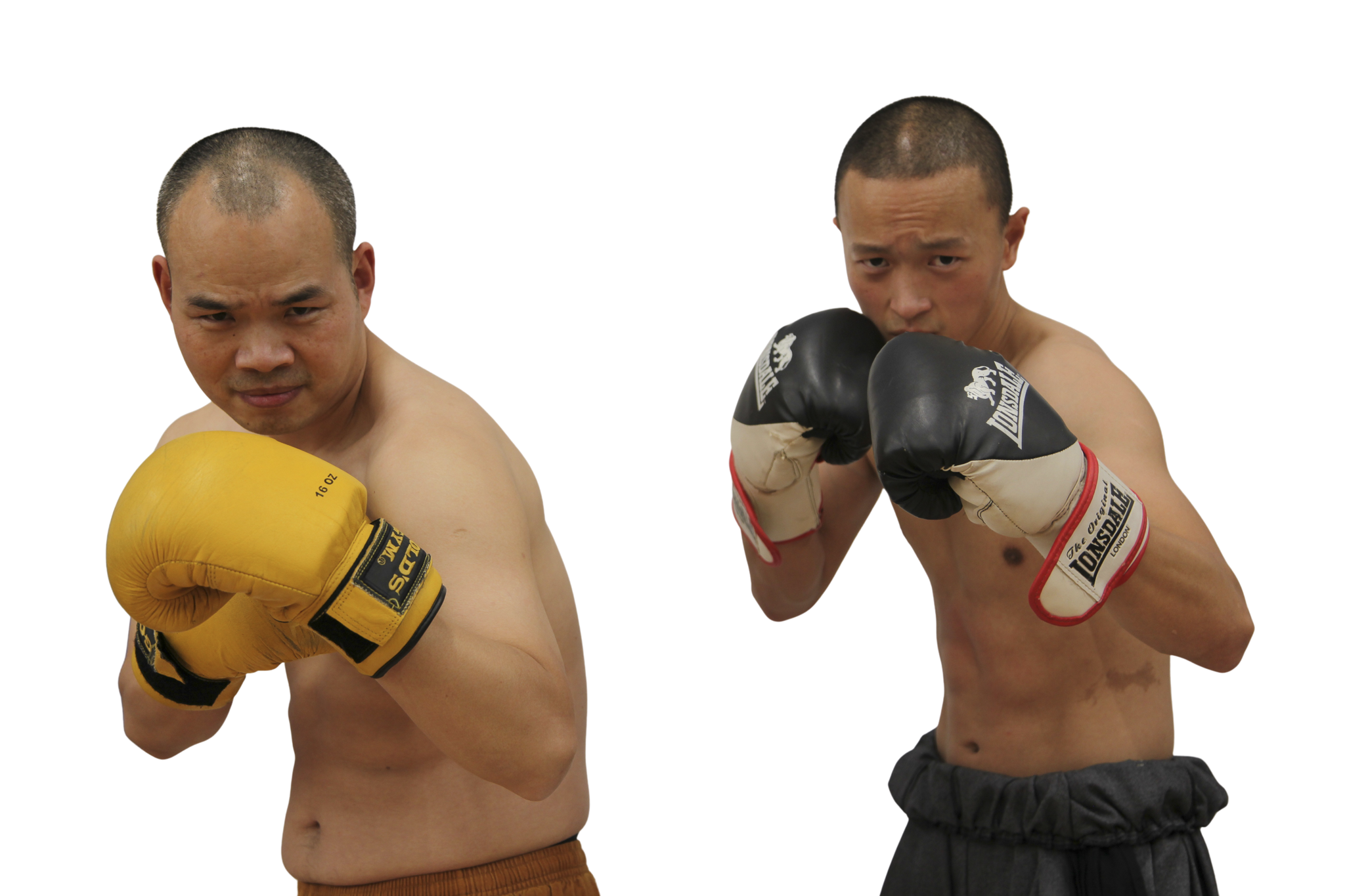 Two shirtless male boxers with shaved heads, one wearing yellow gloves and the other wearing black gloves, in fighting stances facing forward.