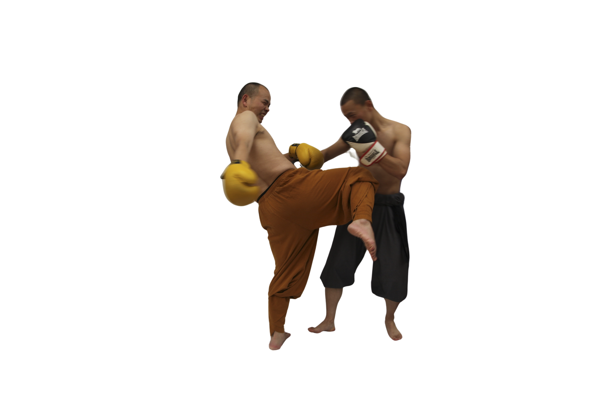 Two shirtless men engaged in a martial arts sparring session wearing padded gloves and loose pants, one delivering a knee strike.martial art london Shaolin Xiu