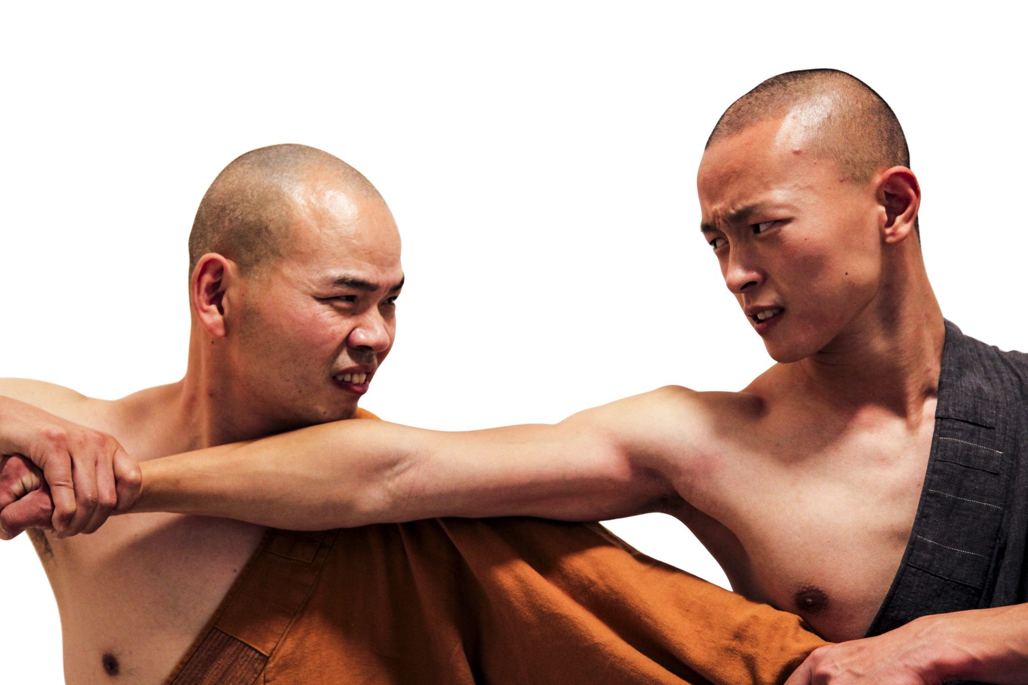 Two men with shaved heads in intense physical confrontation, gripping each other's arms.martial art london Shaolin Xiu