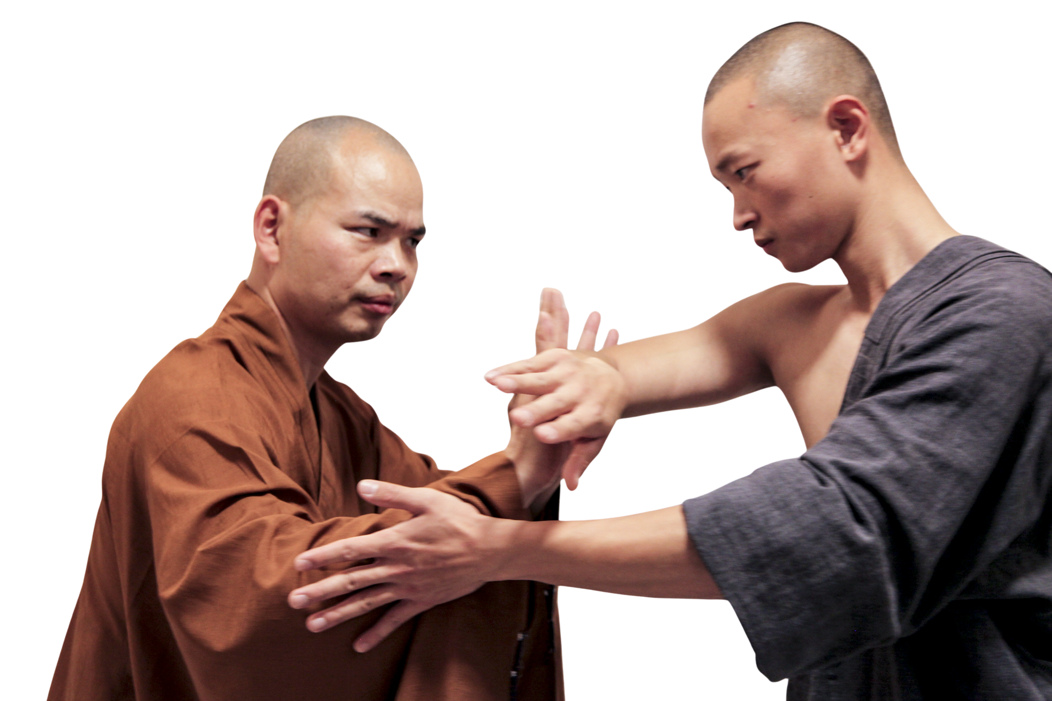 martial art london Shaolin Xiu Two men with shaved heads practicing martial arts hand techniques, one wearing a brown robe and the other a dark gray robe.