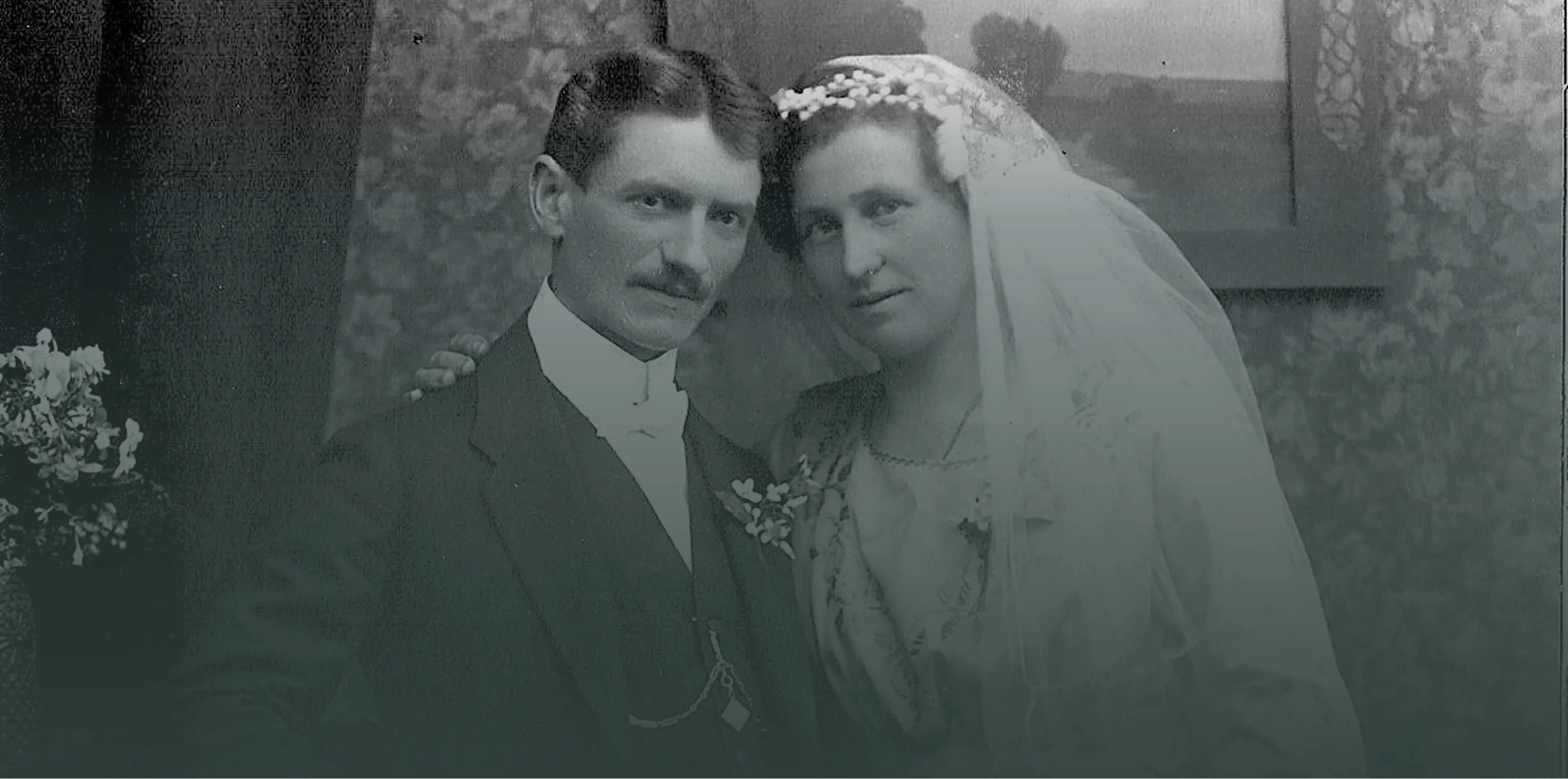Black and white vintage photo of a bride and groom posing together in formal wedding attire.