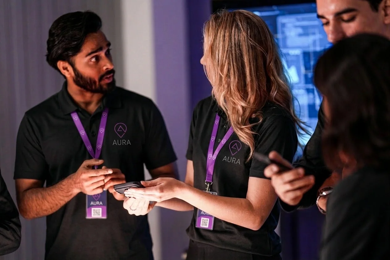 AURA team members in branded shirts connecting with attendees at an industry conference