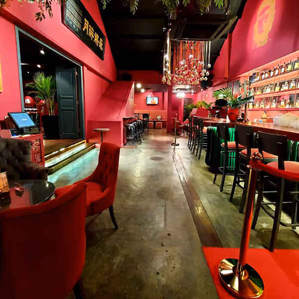 Interior of a vibrant Havana with a long counter, high chairs, decorative plants, and cozy seating areas.