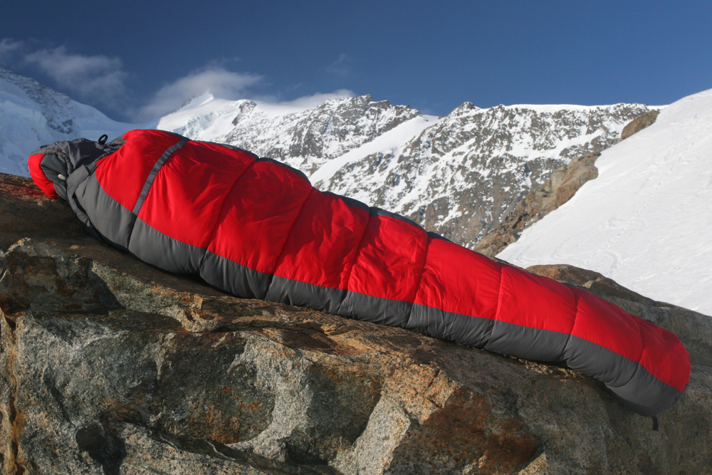 Ours. Winter sleeping bag red in snowy mountains