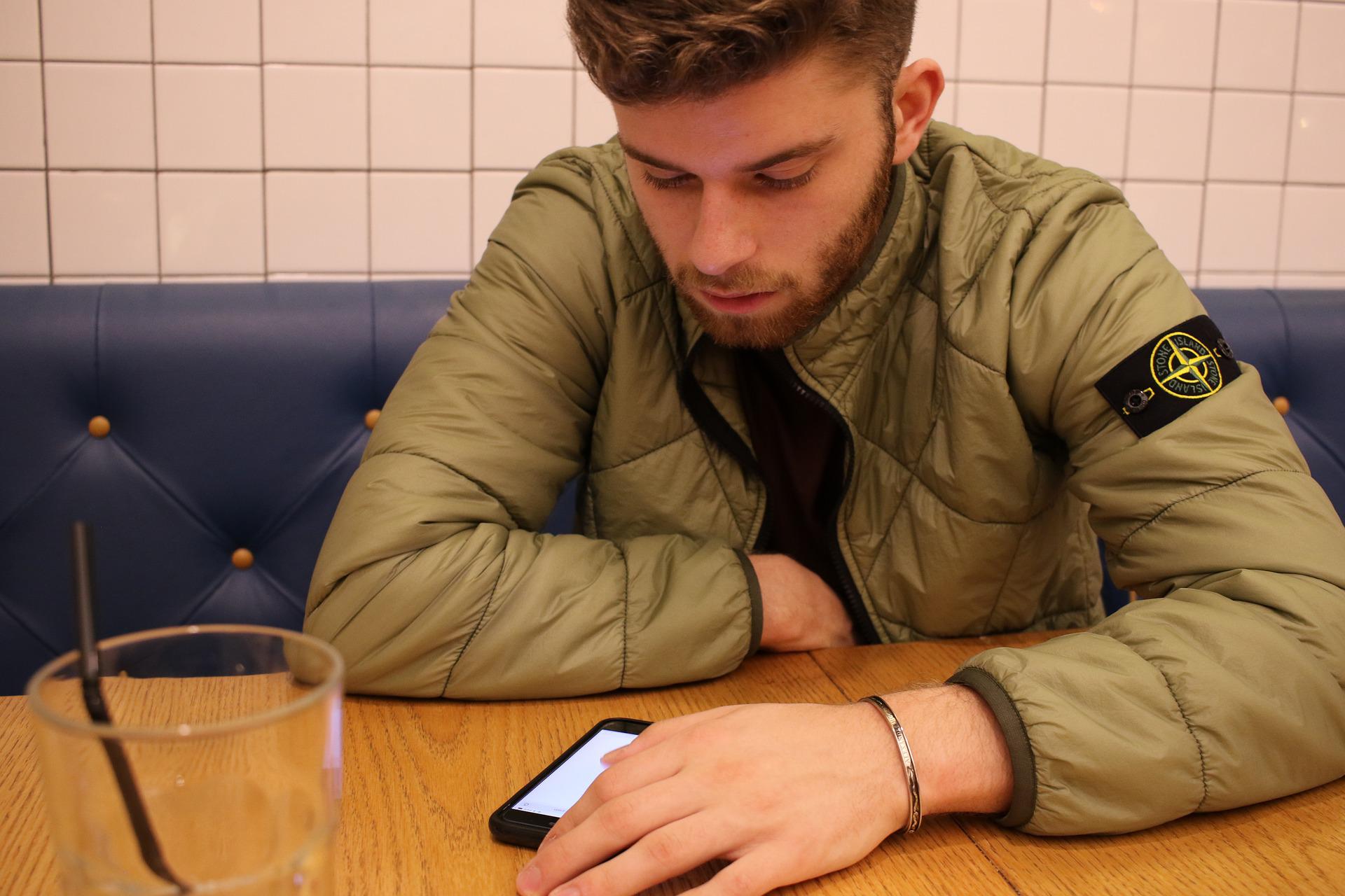 Young man at table looking at cellphone