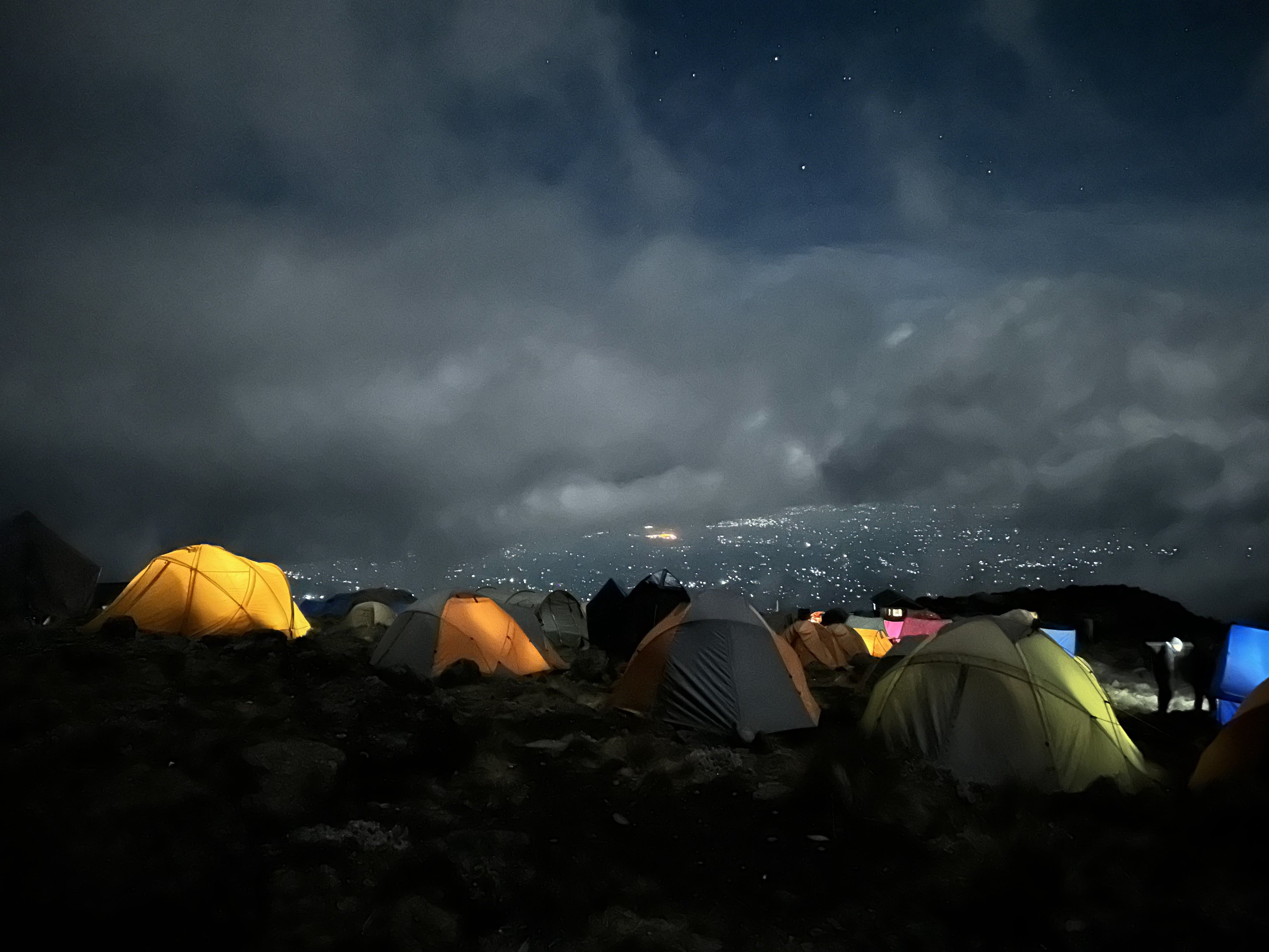 Romy. Kilimanjaro campsite at night with city lights below