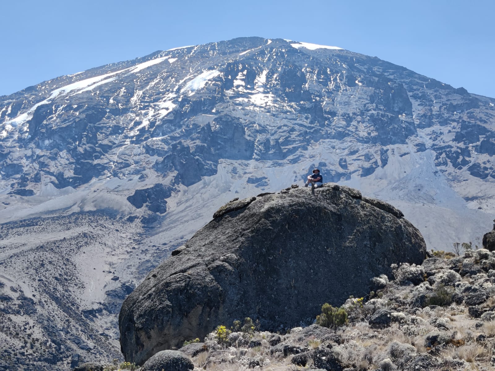 Adrian sitting on rock below Uhuru Peak on Kilimanjaro climb