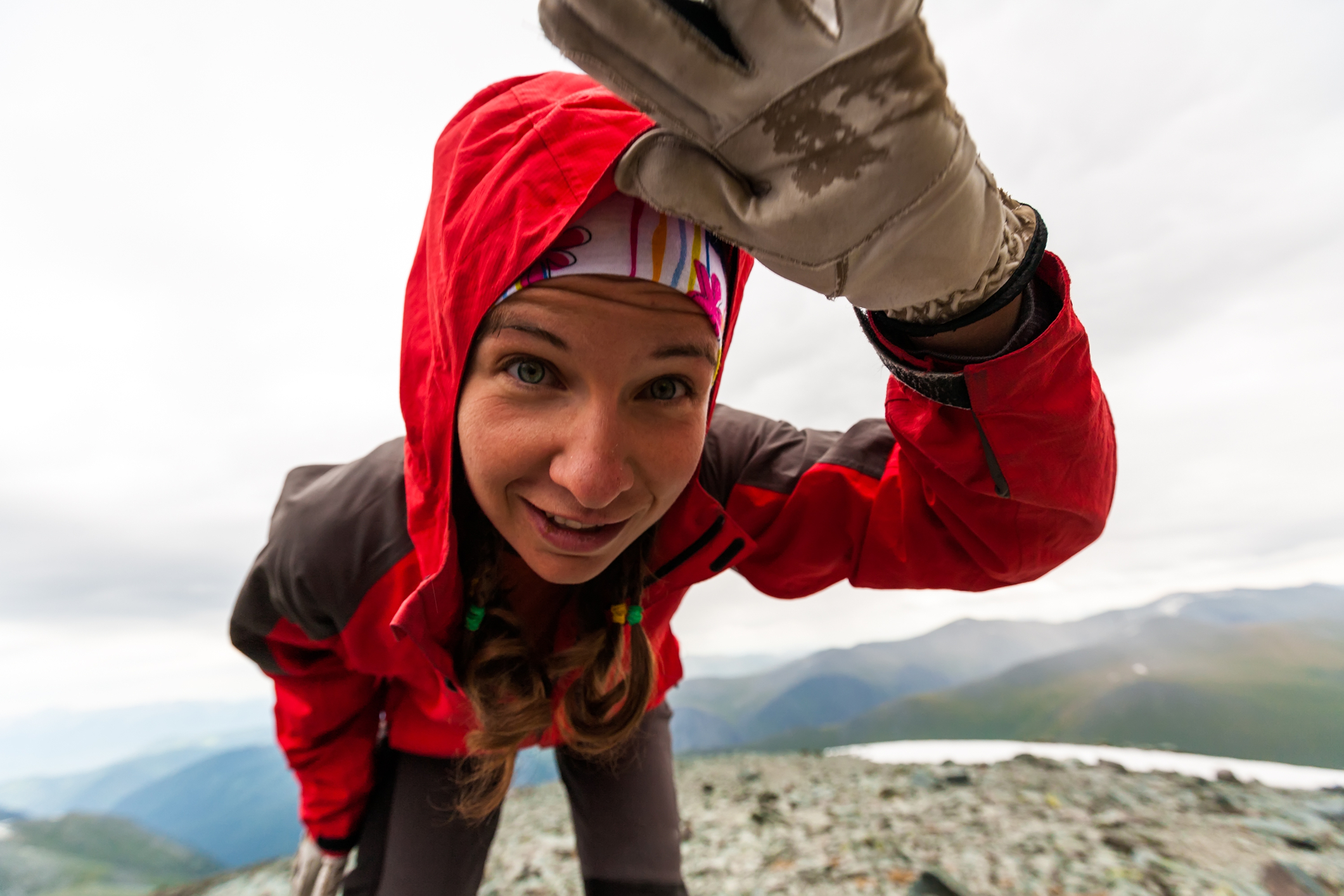 Female trekker in red jacket looking into camera