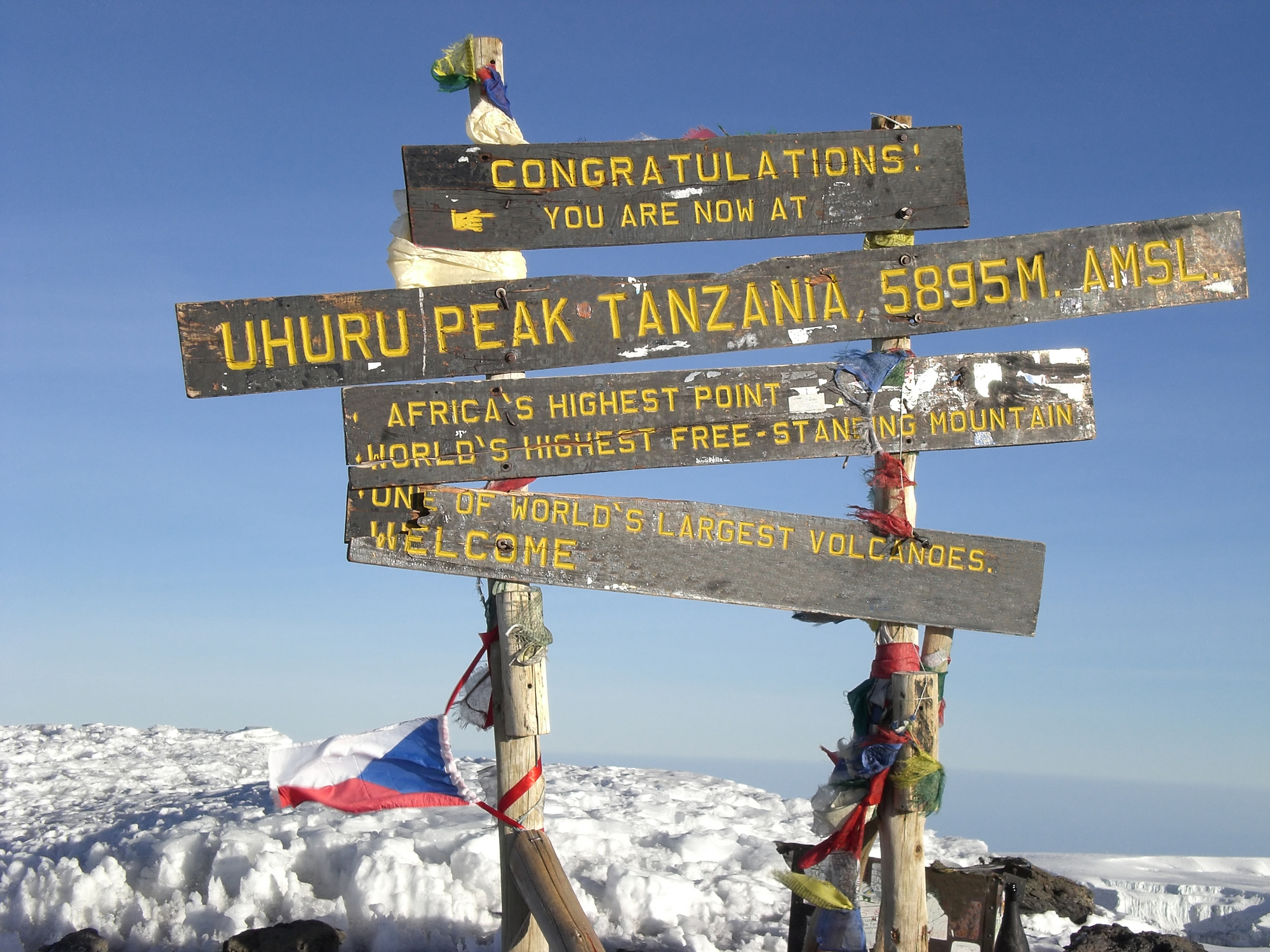Uhuru Peak sign, summit of Kilimanjaro, snow and flags, Tanzania
