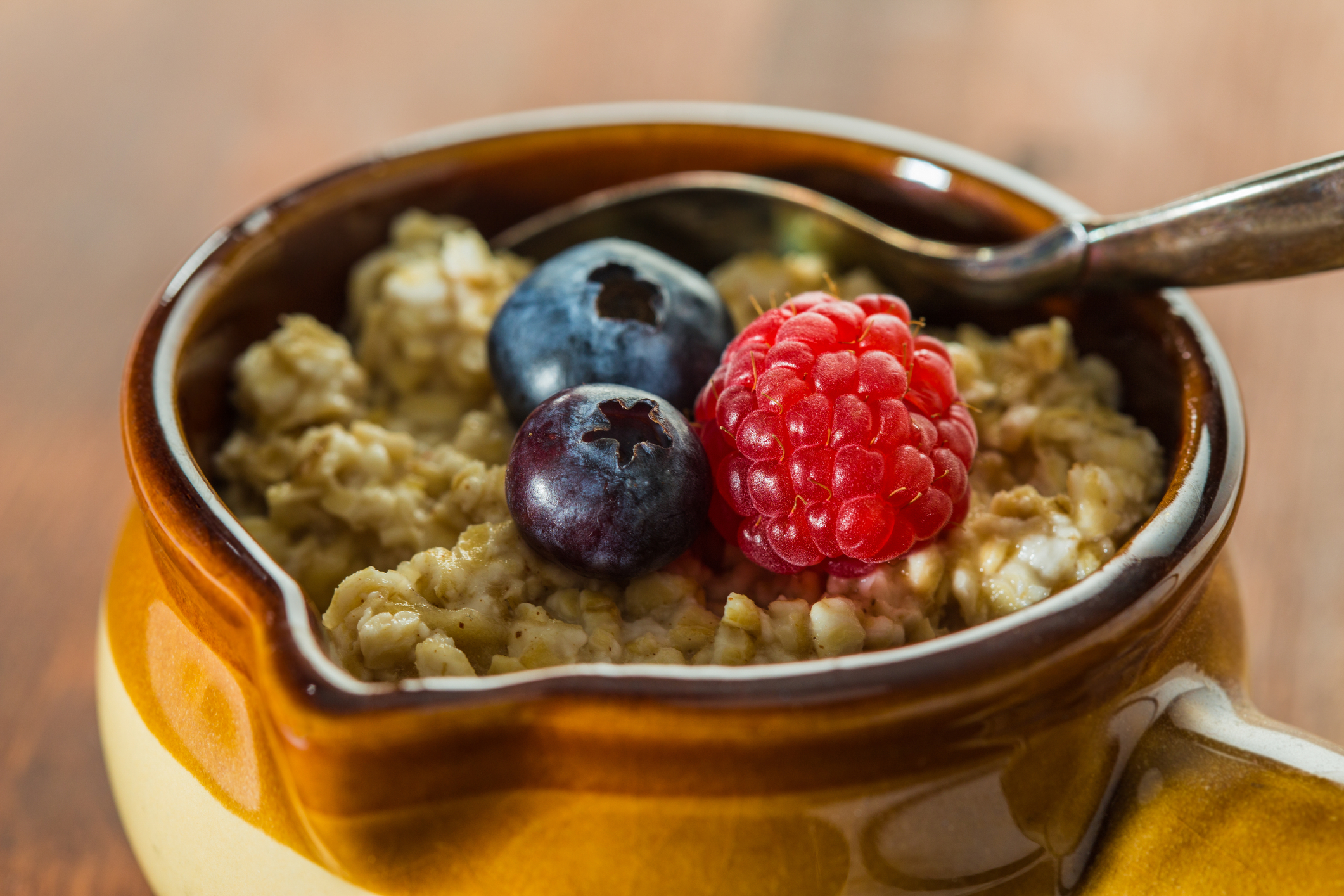 Ours. Hot oats and berries in a bowl with a spoon