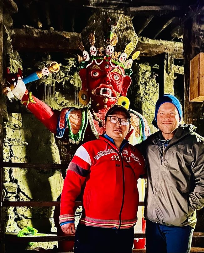 Hala Macknight. Annapurna Circuit trekkers and religious statue