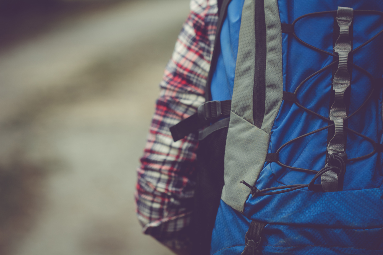 Ours. S. Close up of man wearing blue backpack, shock cord and side pocket