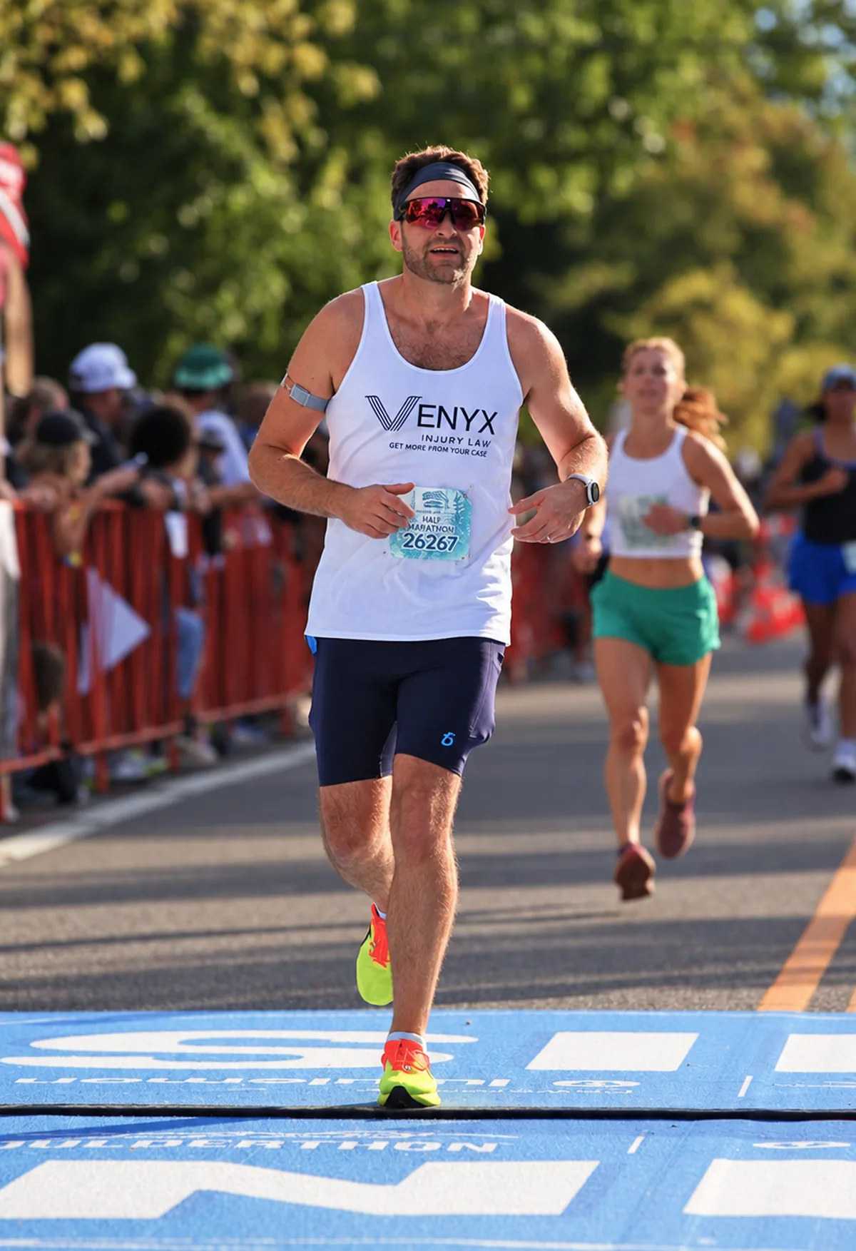 Dylan Unger crossing the Boulderthon half marathon finish line in a Venyx singlet