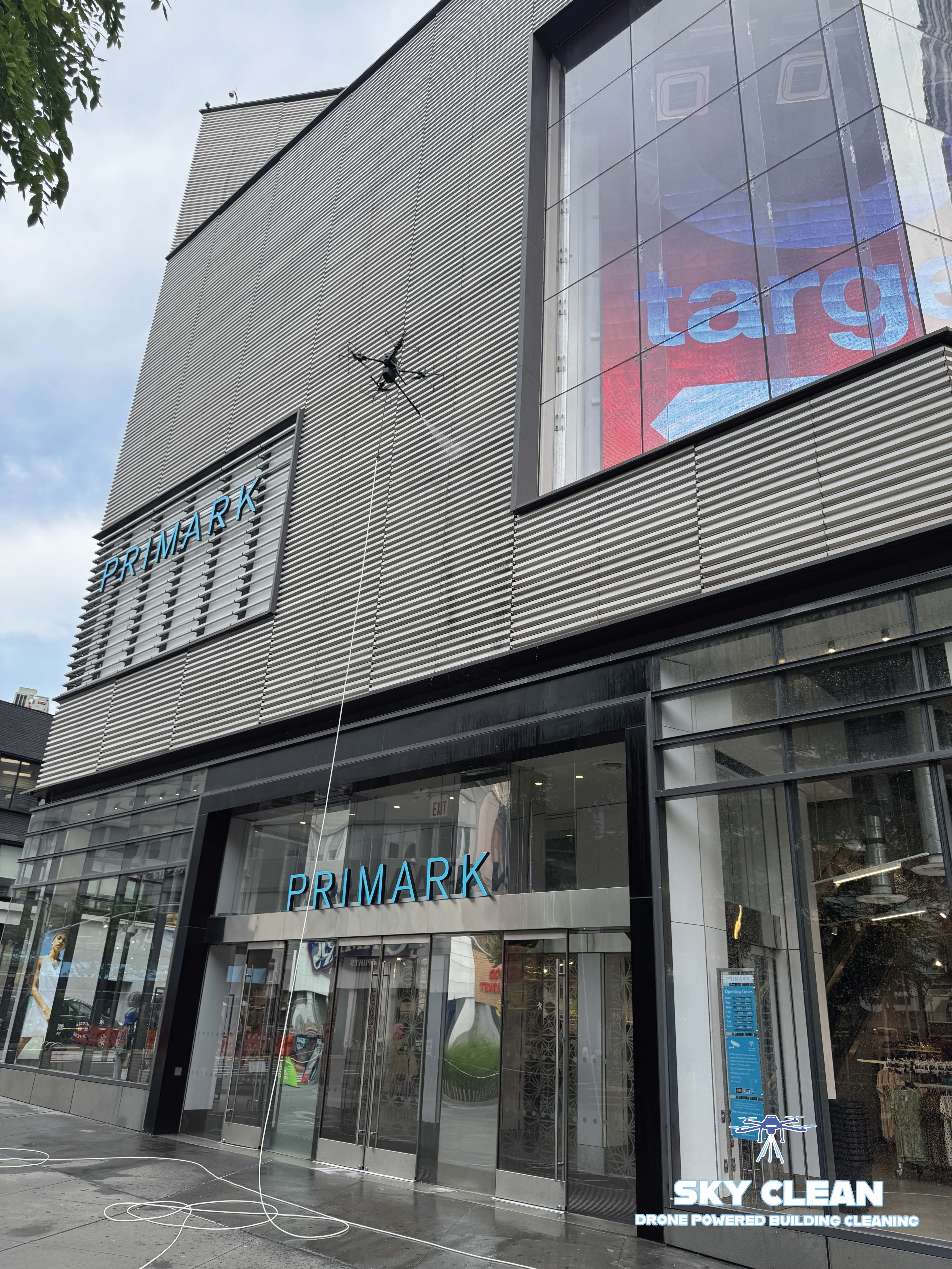 Modern high-rise building viewed from below with abstract geometric mural and blue sky with clouds.