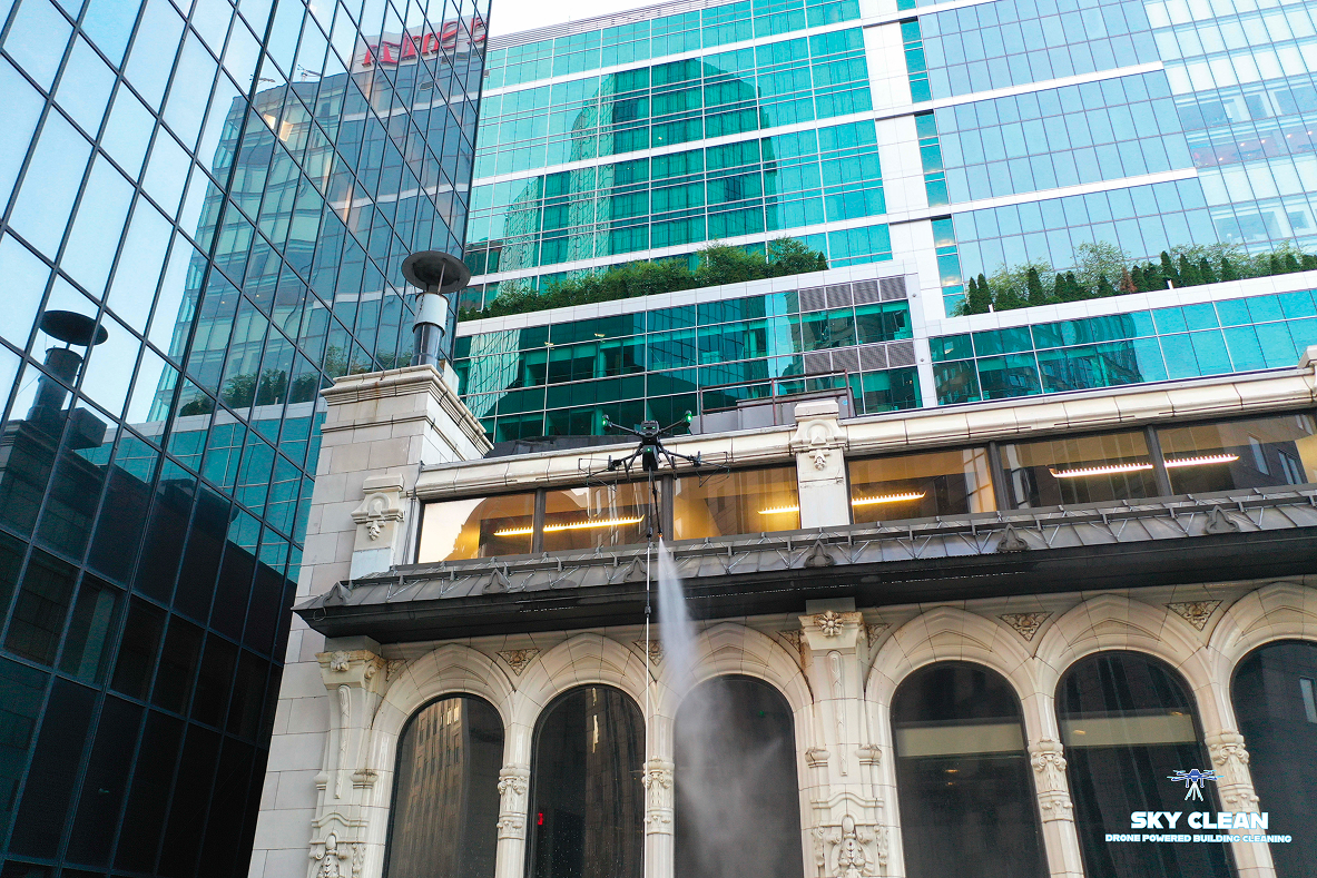 Modern high-rise building viewed from below with abstract geometric mural and blue sky with clouds.