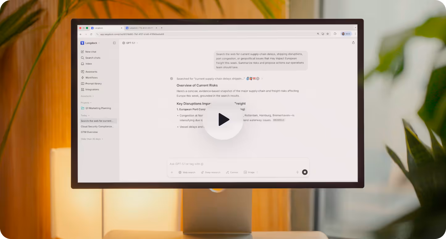 Computer monitor on a desk displaying a Langdock web chat interface with a summary of current supply-chain risks in Europe.