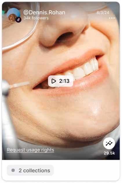 Close-up of a smiling person wearing glasses, showing teeth and part of their face.
