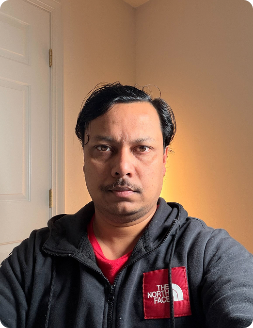 Man in a yellow life jacket leaning close to a dolphin in the water, with the dolphin touching his face.