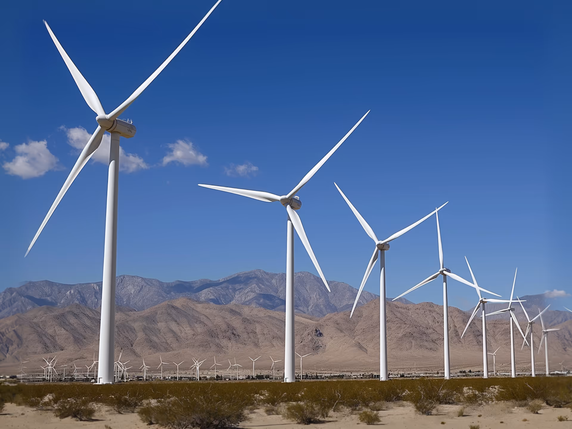 Team collaborating around a table with a notebook showing diagrams and colorful paper shapes.