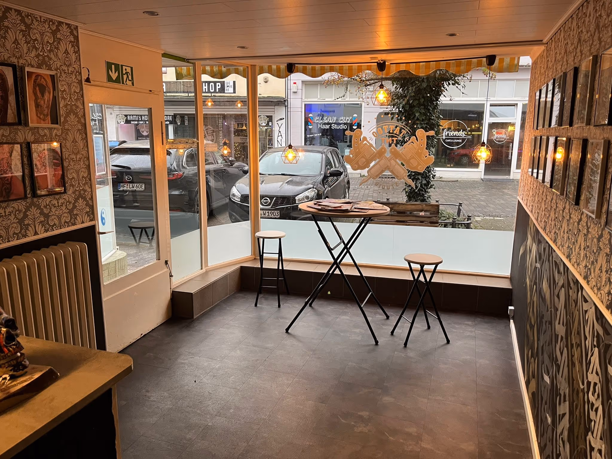 Blick von der linken Seite des Tnt-Tattoo Studios in Herford in der Innenstadt nach draußen auf den Gänsemarkt, Innenwände mit Tattoo-Bildern sichtbar.